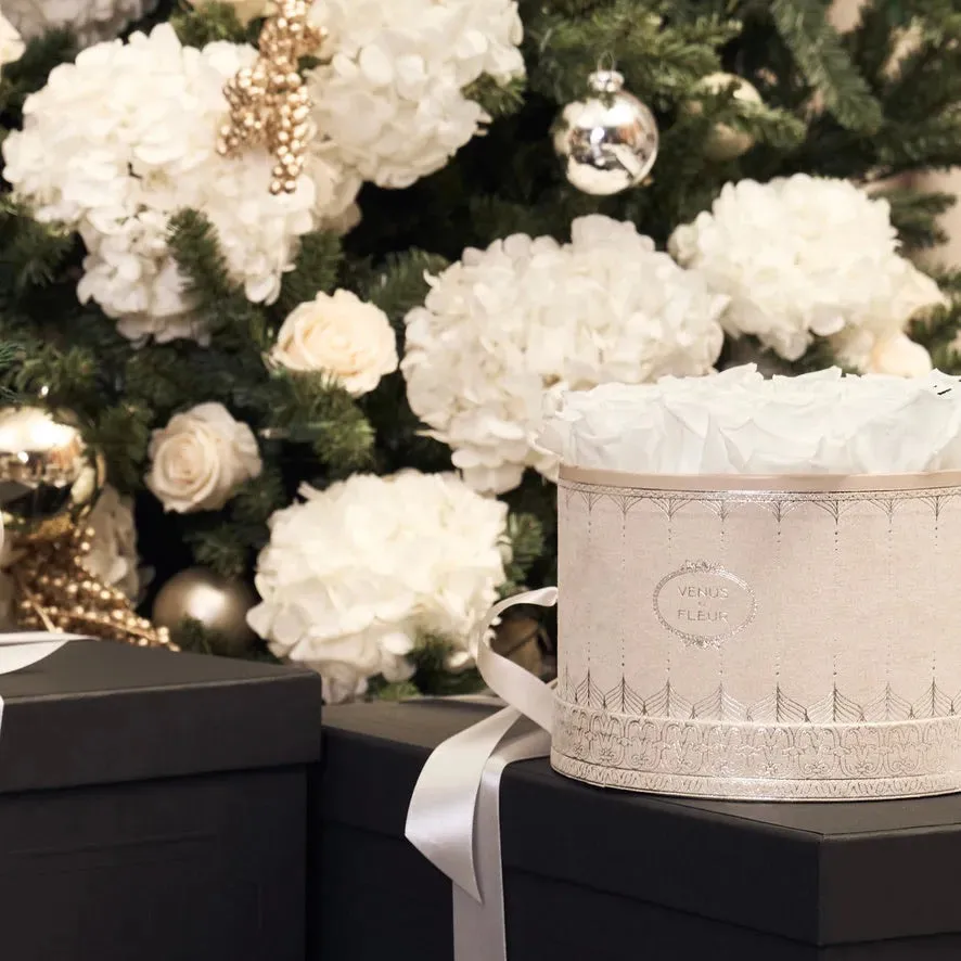 White Eternity® Roses in a Déco Délicate hatbox styled with holiday gifts
